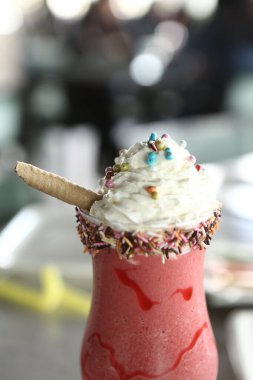 Bir bardak ahududu milkshake, krem şanti ve taze ahududu.