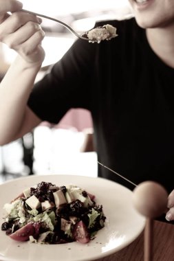 çekici beyaz salata, odak üstünde el yemek kadın ve çatal gülümseyen portresi.