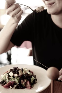 çekici beyaz salata, odak üstünde el yemek kadın ve çatal gülümseyen portresi.