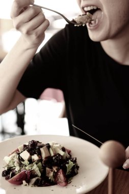 çekici beyaz salata, odak üstünde el yemek kadın ve çatal gülümseyen portresi.