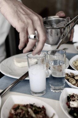 Turkish and Greek Traditional Dinning Table with Special Alcohol Drink Raki. Ouzo and Turkish Raki is a dry anise flavoured aperitif that is widely consumed in Turkey, Greece, Cyprus and Lebanon clipart