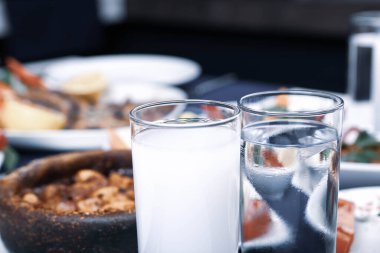 Özel Alkollü İçkili Rakılı Türk ve Yunan Geleneksel Yemek Masası. Uzo ve Türk Rakısı, Türkiye, Yunanistan, Kıbrıs ve Lübnan'da yaygın olarak tüketilen kuru anason aromalı bir aperatiftir.