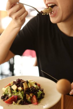 çekici beyaz salata, odak üstünde el yemek kadın ve çatal gülümseyen portresi.