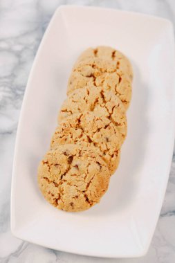 Bir grup çeşit kurabiye. Çikolata parçacıklı, yulaflı, kuru üzümlü, beyaz çikolatalı.