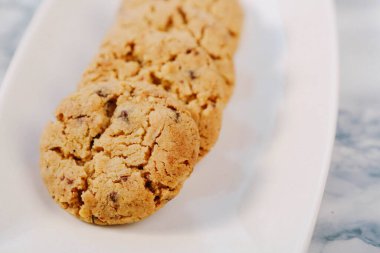 Bir grup çeşit kurabiye. Çikolata parçacıklı, yulaflı, kuru üzümlü, beyaz çikolatalı.