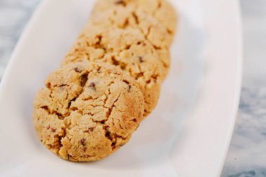 Bir grup çeşit kurabiye. Çikolata parçacıklı, yulaflı, kuru üzümlü, beyaz çikolatalı.