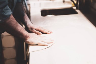 Pizza şefi ticari bir mutfakta sosu tabana koydu.