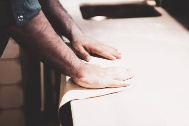 Pizza şefi ticari bir mutfakta sosu tabana koydu.