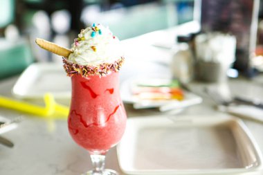 Bir bardak ahududu milkshake, krem şanti ve taze ahududu.