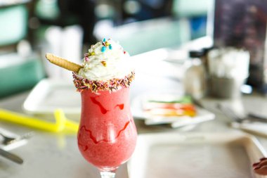 Bir bardak ahududu milkshake, krem şanti ve taze ahududu.