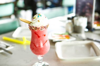 Bir bardak ahududu milkshake, krem şanti ve taze ahududu.