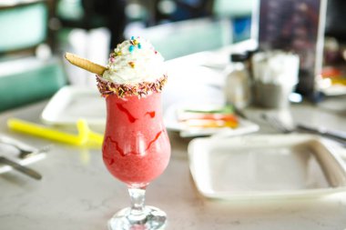 Bir bardak ahududu milkshake, krem şanti ve taze ahududu.