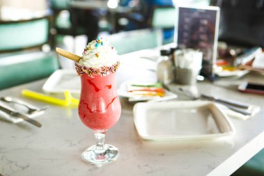 Bir bardak ahududu milkshake, krem şanti ve taze ahududu.