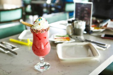 Bir bardak ahududu milkshake, krem şanti ve taze ahududu.