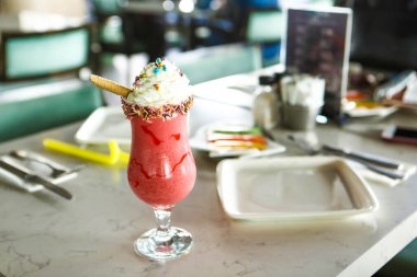 Bir bardak ahududu milkshake, krem şanti ve taze ahududu.