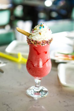 Bir bardak ahududu milkshake, krem şanti ve taze ahududu.