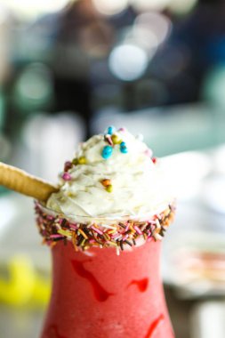 Bir bardak ahududu milkshake, krem şanti ve taze ahududu.