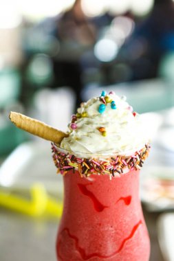 Bir bardak ahududu milkshake, krem şanti ve taze ahududu.