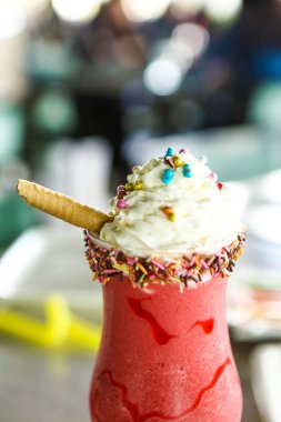 Bir bardak ahududu milkshake, krem şanti ve taze ahududu.