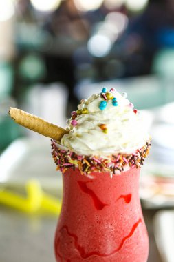 Bir bardak ahududu milkshake, krem şanti ve taze ahududu.