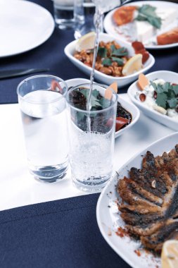 Özel Alkollü İçkili Rakılı Türk ve Yunan Geleneksel Yemek Masası. Uzo ve Türk Rakısı, Türkiye, Yunanistan, Kıbrıs ve Lübnan'da yaygın olarak tüketilen kuru anason aromalı bir aperatiftir.