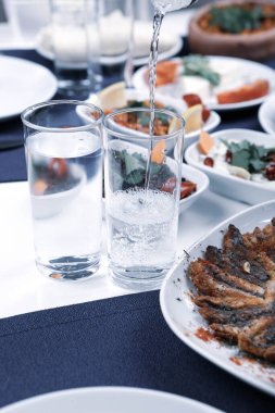 Özel Alkollü İçkili Rakılı Türk ve Yunan Geleneksel Yemek Masası. Uzo ve Türk Rakısı, Türkiye, Yunanistan, Kıbrıs ve Lübnan'da yaygın olarak tüketilen kuru anason aromalı bir aperatiftir.