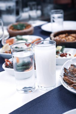 Özel Alkollü İçkili Rakılı Türk ve Yunan Geleneksel Yemek Masası. Uzo ve Türk Rakısı, Türkiye, Yunanistan, Kıbrıs ve Lübnan'da yaygın olarak tüketilen kuru anason aromalı bir aperatiftir.