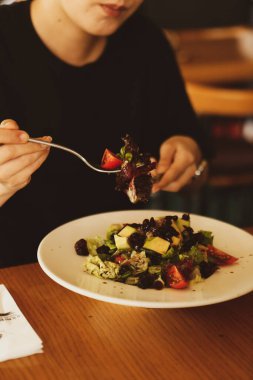 çekici beyaz salata, odak üstünde el yemek kadın ve çatal gülümseyen portresi.