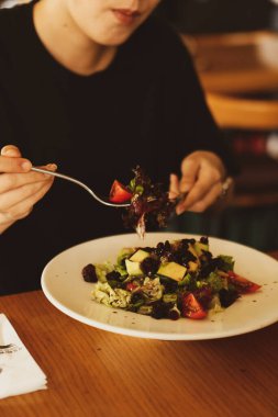 çekici beyaz salata, odak üstünde el yemek kadın ve çatal gülümseyen portresi.