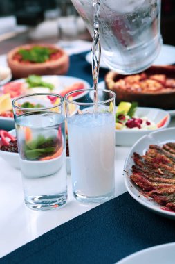 Özel Alkollü İçkili Rakılı Türk ve Yunan Geleneksel Yemek Masası. Uzo ve Türk Rakısı, Türkiye, Yunanistan, Kıbrıs ve Lübnan'da yaygın olarak tüketilen kuru anason aromalı bir aperatiftir.