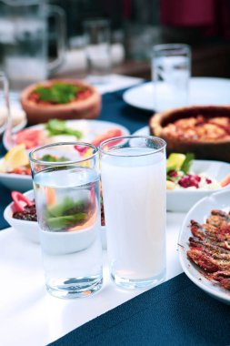 Özel Alkollü İçkili Rakılı Türk ve Yunan Geleneksel Yemek Masası. Uzo ve Türk Rakısı, Türkiye, Yunanistan, Kıbrıs ve Lübnan'da yaygın olarak tüketilen kuru anason aromalı bir aperatiftir.