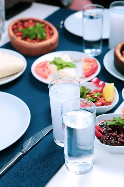 トルコとギリシャの伝統的なダイニングテーブル 特別なアルコールドリンクラキ付 ウーゾとトルコのラキは トルコ ギリシャ キプロス レバノンで広く消費されている乾燥したアニス風味の食前炎です — ストック写真