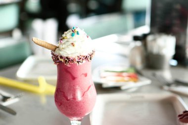 Bir bardak ahududu milkshake, krem şanti ve taze ahududu.