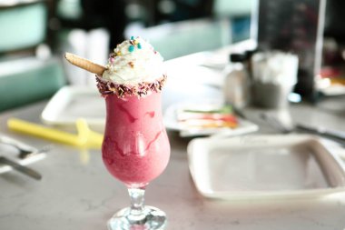 Bir bardak ahududu milkshake, krem şanti ve taze ahududu.