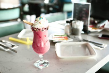 Bir bardak ahududu milkshake, krem şanti ve taze ahududu.