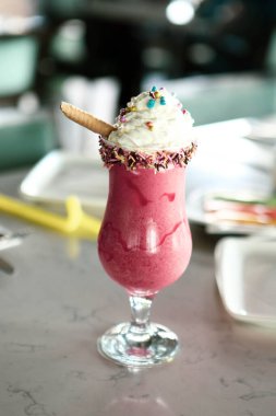 Bir bardak ahududu milkshake, krem şanti ve taze ahududu.