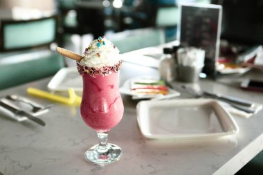 Bir bardak ahududu milkshake, krem şanti ve taze ahududu.