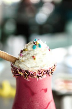 Bir bardak ahududu milkshake, krem şanti ve taze ahududu.