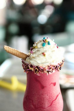 Bir bardak ahududu milkshake, krem şanti ve taze ahududu.