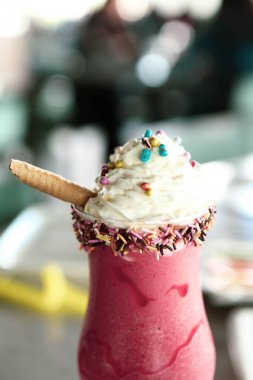 Bir bardak ahududu milkshake, krem şanti ve taze ahududu.