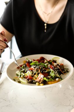 çekici beyaz salata, odak üstünde el yemek kadın ve çatal gülümseyen portresi.