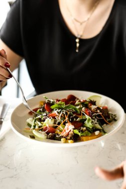 çekici beyaz salata, odak üstünde el yemek kadın ve çatal gülümseyen portresi.