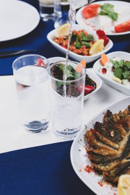 Özel Alkollü İçkili Rakılı Türk ve Yunan Geleneksel Yemek Masası. Uzo ve Türk Rakısı, Türkiye, Yunanistan, Kıbrıs ve Lübnan'da yaygın olarak tüketilen kuru anason aromalı bir aperatiftir.