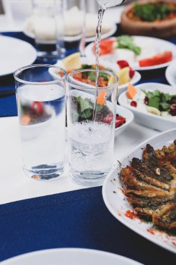 Özel Alkollü İçkili Rakılı Türk ve Yunan Geleneksel Yemek Masası. Uzo ve Türk Rakısı, Türkiye, Yunanistan, Kıbrıs ve Lübnan'da yaygın olarak tüketilen kuru anason aromalı bir aperatiftir.