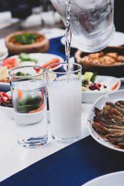 Özel Alkollü İçkili Rakılı Türk ve Yunan Geleneksel Yemek Masası. Uzo ve Türk Rakısı, Türkiye, Yunanistan, Kıbrıs ve Lübnan'da yaygın olarak tüketilen kuru anason aromalı bir aperatiftir.
