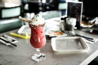 Bir bardak ahududu milkshake, krem şanti ve taze ahududu.