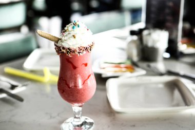 Bir bardak ahududu milkshake, krem şanti ve taze ahududu.