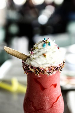 Bir bardak ahududu milkshake, krem şanti ve taze ahududu.