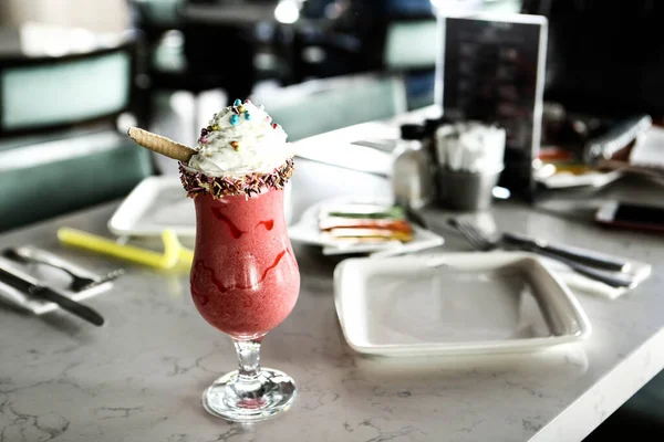 Bir bardak ahududu milkshake, krem şanti ve taze ahududu.