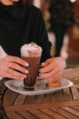 Sütlü buzlu kahve. Buzlu kahve. Elinde bir bardak buzlu kahve tutan kadın..